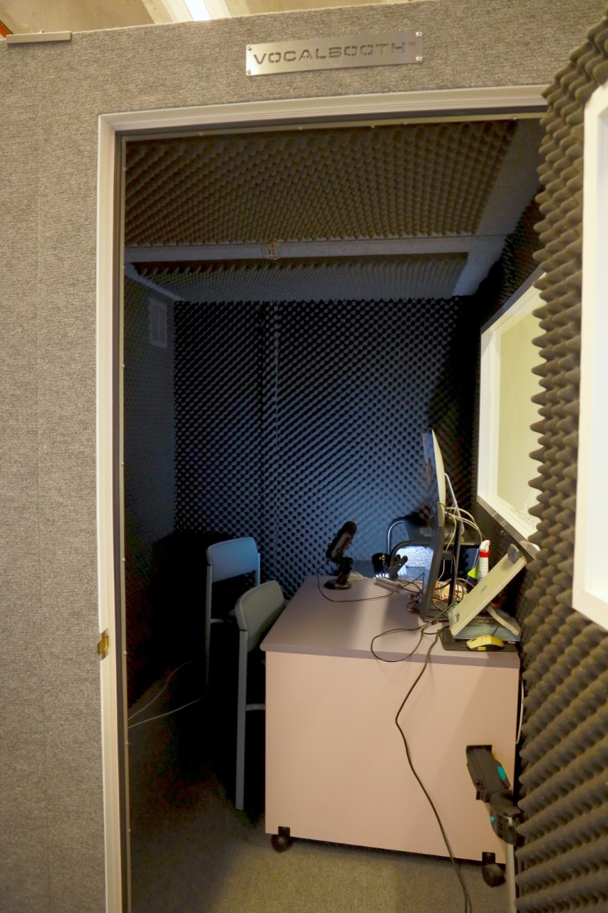 a photo of the sound recording booth - a small room with a computer, mic and insulated walls 